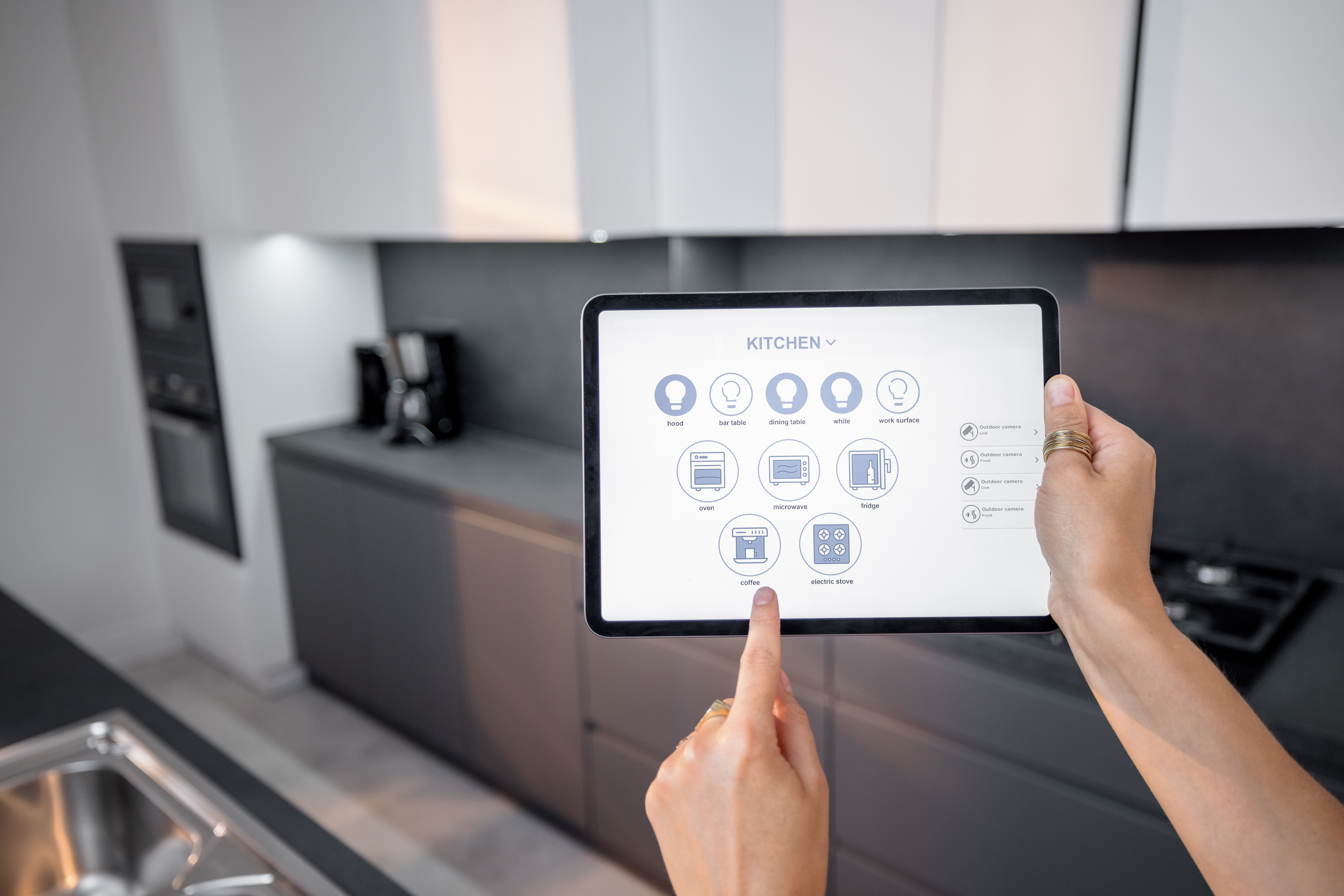Digitales Tablet mit laufender mobiler Anwendung zur Steuerung intelligenter Geräte in der Küche.Frau steuert intelligente Geräte zu Hause aus der Ferne.Smart-Home-Konzept